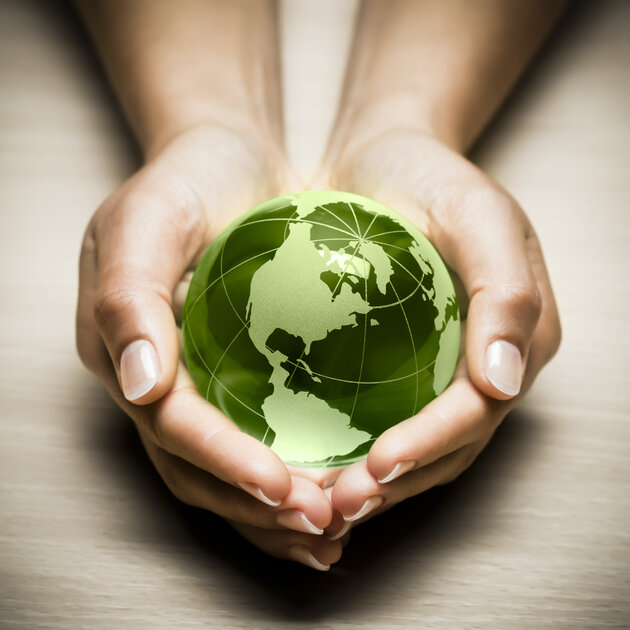 Bild på två händer som håller i en grön jordglob